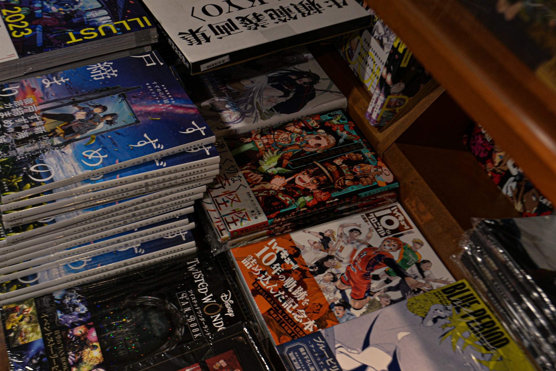 a pile of comic books sitting on top of a wooden table
